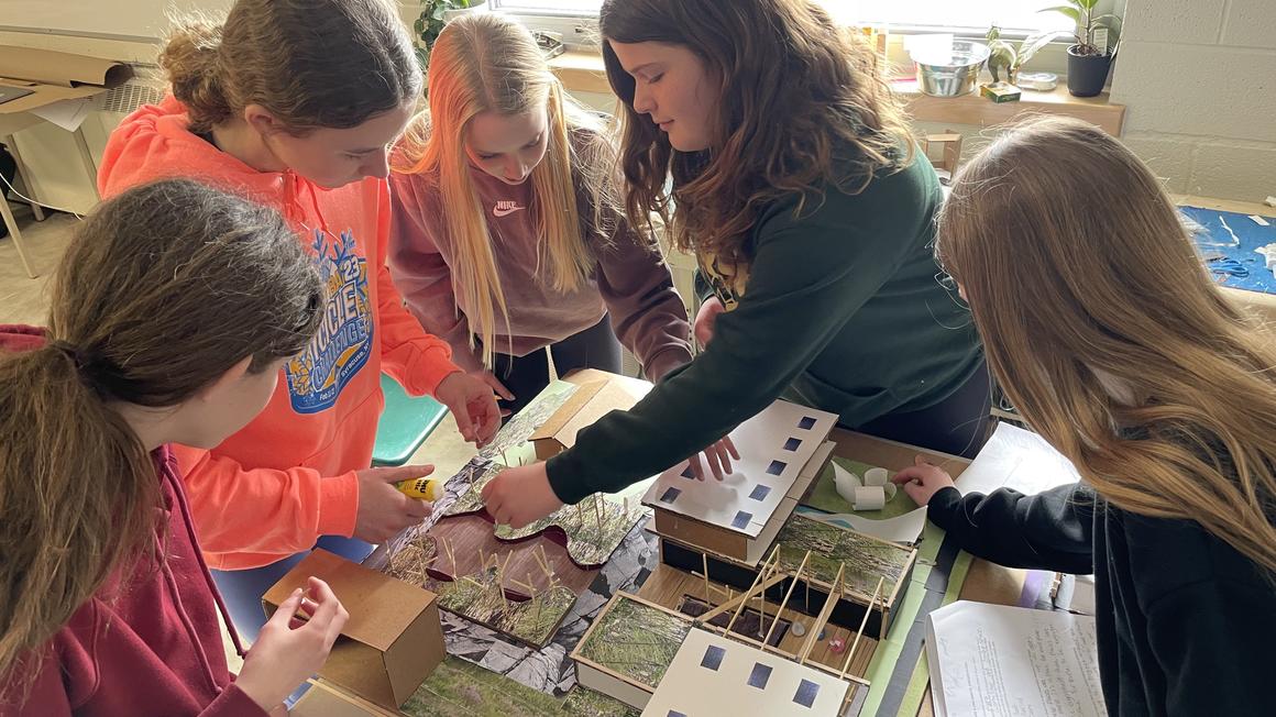 Five girls building sustainable community diorama on desk