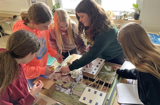 Five girls building sustainable community diorama on desk